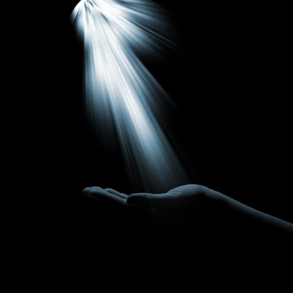 A glimmer of hope flowing down to the hand of the woman on a dark background. The light of faith — Stock Photo, Image