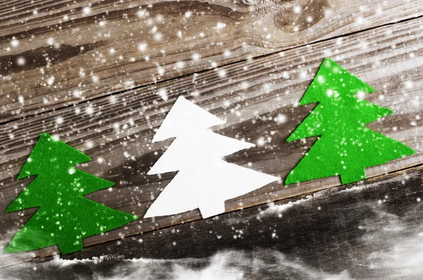 Choinki trzy białe i zielone wykonane z filcu na tle drewniane, śnieżne. Rzemiosła — Zdjęcie stockowe