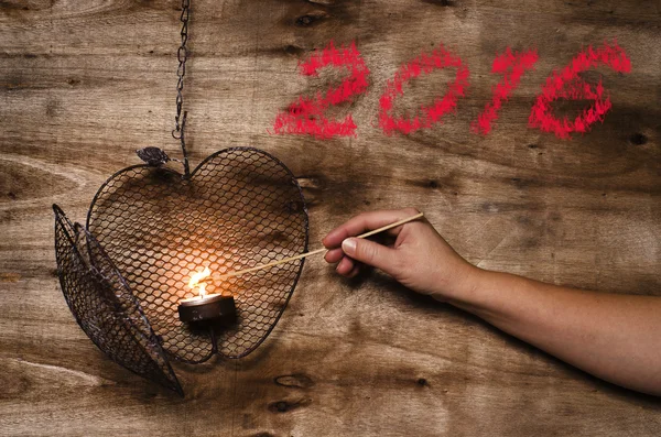 New year 2016 written on wooden background. Lighting the heart. — Stock Photo, Image