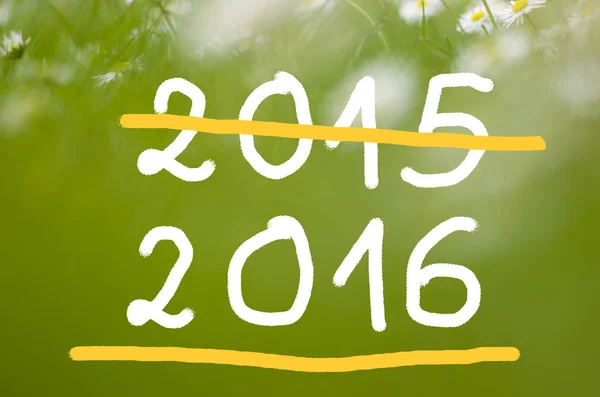Datum 2015 kommer att 2016 handskriven på verkliga naturliga grön bakgrund. — Stockfoto