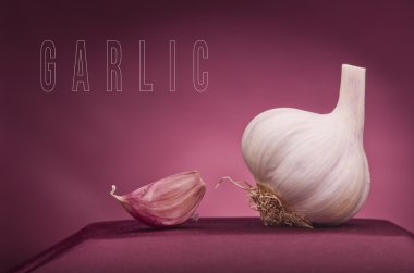 Sarımsak kırmızı zemin üzerine. Sarımsak bir heykel olarak.