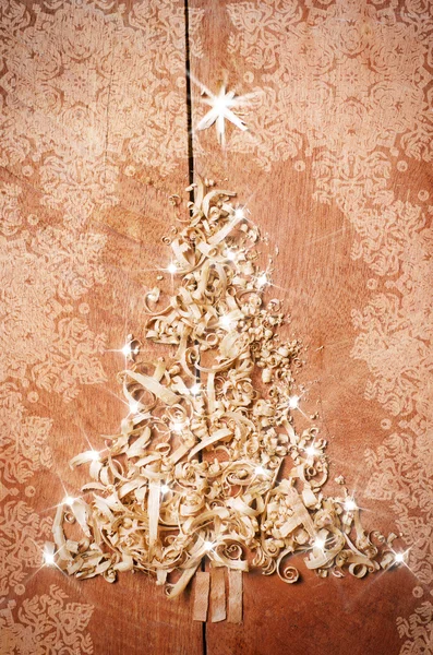 Egyszerű karácsonyfa rendezve a fűrészpor, fa-chipek a fából készült háttér. — Stock Fotó