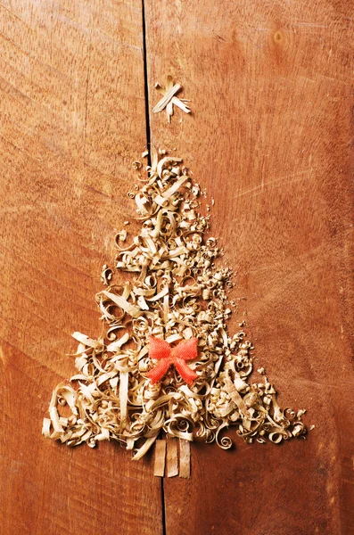 간단한 크리스마스 나무 톱 밥, 나무 칩 나무 배경에서 배열. 주황색 귀여운 리본. — 스톡 사진