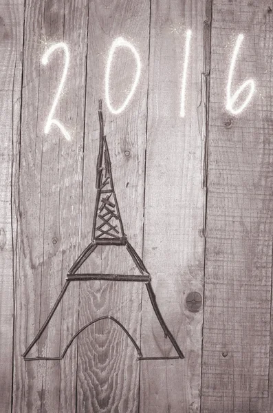 Eiffel Tower arranged from wooden sticks.Date 2016 written on grey background. — Stock Photo, Image