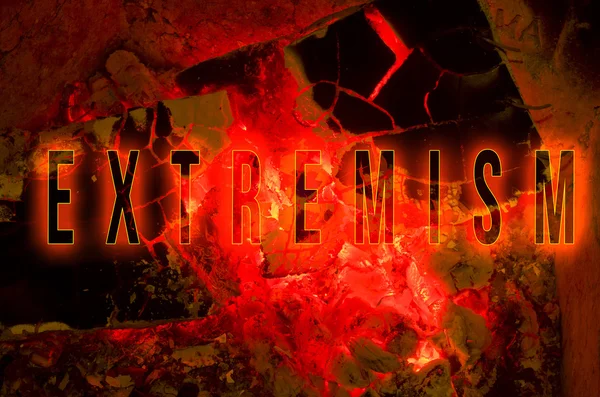 Word extremism written on red hot wood embers detail in fire place. — Stock Photo, Image