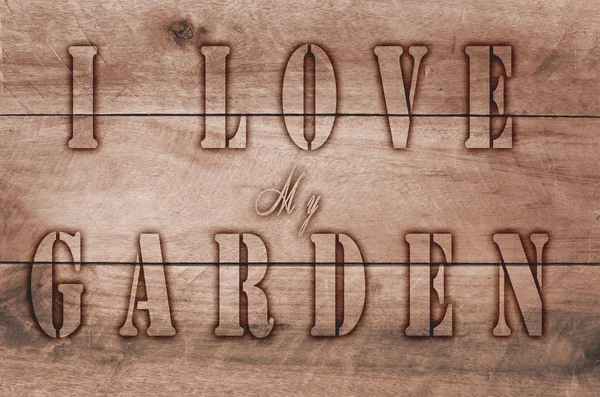 Palavra Eu amo meu jardim escrito, cartas queimadas em fundo marrom de madeira . — Fotografia de Stock