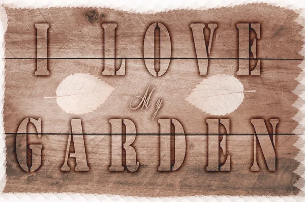 Word I love my garden written, burned letters on wooden brown background. — Stock Photo, Image