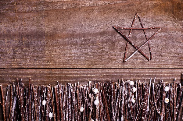 Handmade star on wooden background. Craft arranged from sticks, twigs, driftwood and pine cones white and shiny. — 图库照片