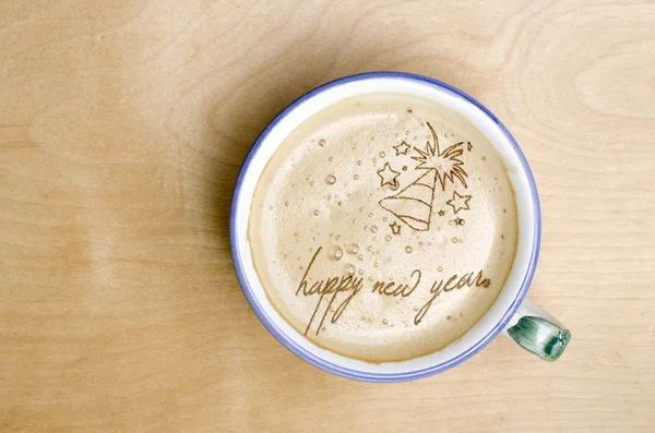Kubek kawa na drewnianym stole. Słowa szczęśliwego nowego roku z pianki kawy — Zdjęcie stockowe
