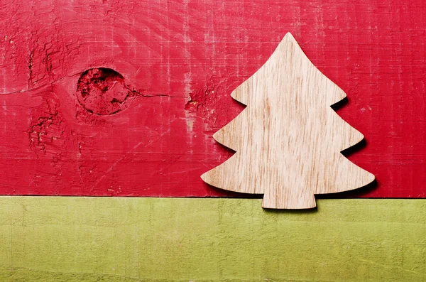 Jednoduché dřevěné vánoční strom na zelené a červené dřevěné pozadí — Stock fotografie