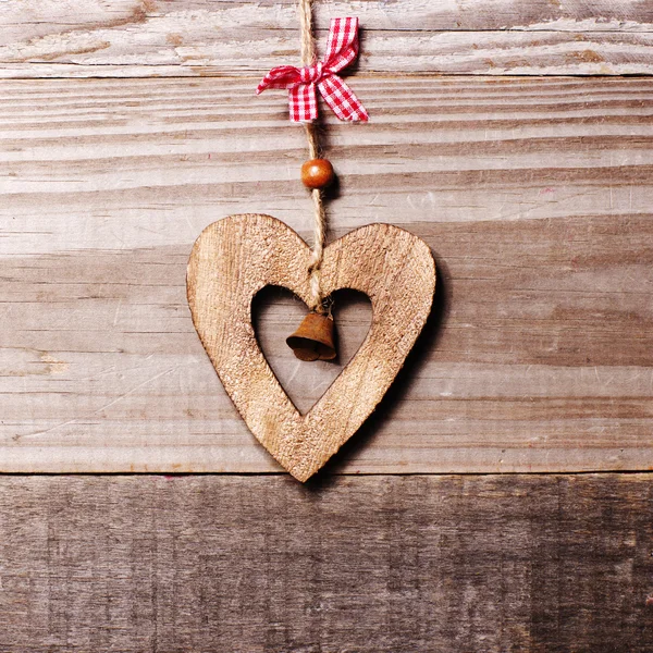 Trä hjärta med bell dekoration på vintage oak bakgrund, utrymme för din text. — Stockfoto