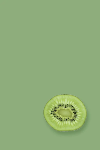 Fatia de kiwi fresco isolado em um fundo verde . — Fotografia de Stock