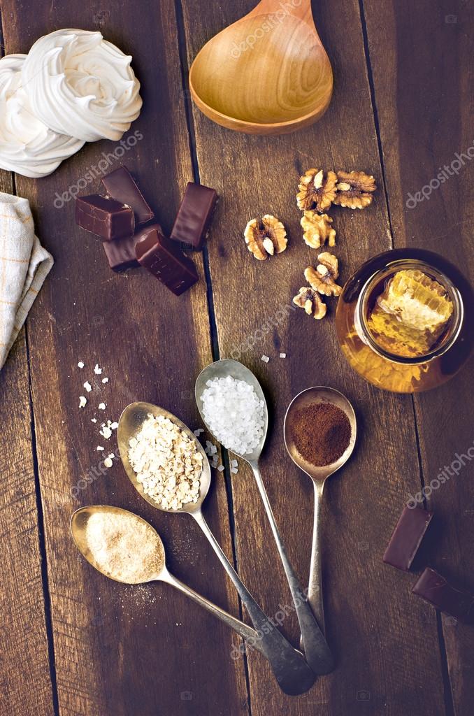 Overhead view of chocolate marshmallow with ingredients and kitchen utensils on a light rustic wood table. Open space for logo or text.