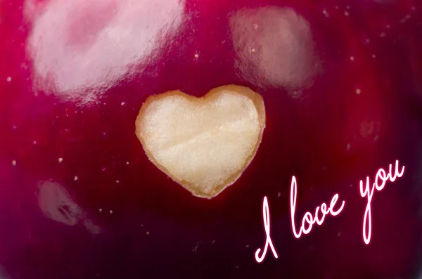 Texto Eu te amo escrito em maçã vermelha fresca com um corte em forma de coração close-up. Alimentação saudável, conceito de vida. Organismos geneticamente modificados isentos de OGM. Dia dos namorados . — Fotografia de Stock