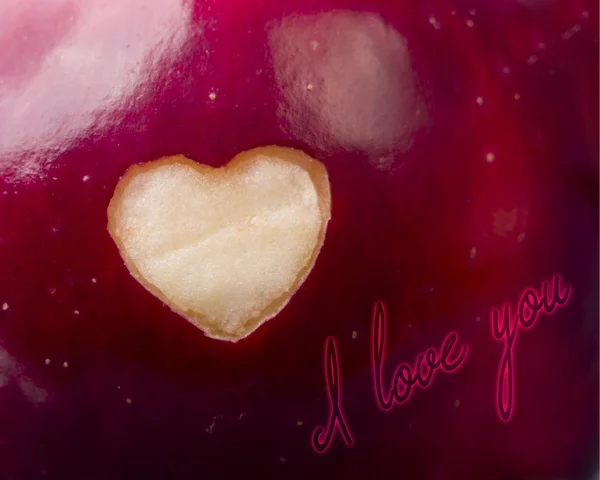 Texto Eu te amo escrito em maçã vermelha fresca com um corte em forma de coração close-up. Alimentação saudável, conceito de vida. Organismos geneticamente modificados isentos de OGM. Dia dos namorados . — Fotografia de Stock