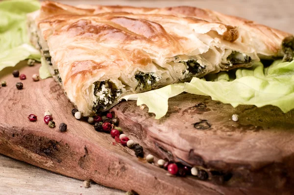 Espinafre e queijo enrolados borek, refeição tradicional turca em fundo de madeira . — Fotografia de Stock