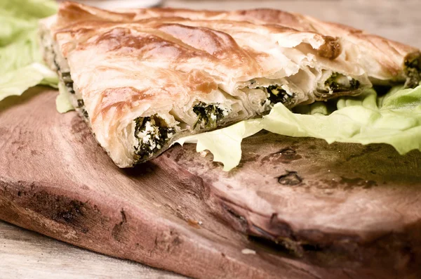 Espinafre e queijo enrolados borek, refeição tradicional turca em fundo de madeira . — Fotografia de Stock