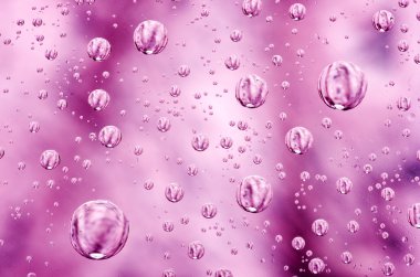 Su arka plan pembe yüzeye bırakır. Yansımalar onları ile cam üzerinde Su damlacıkları.
