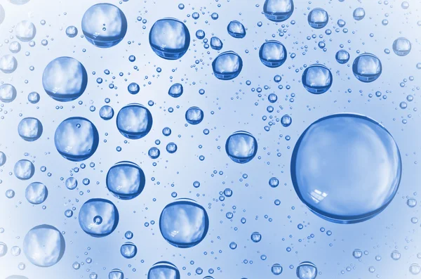 Hintergrund von Wassertropfen auf Glas. Wassertropfen auf Glas mit blauem Hintergrund. — Stockfoto