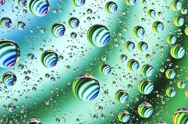Water drops background on green surface. Water droplets with reflections in them. — Stock Photo, Image