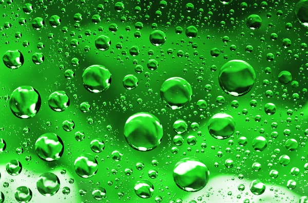 Water drops background on green surface. Water droplets with reflections in them. — Stock Photo, Image