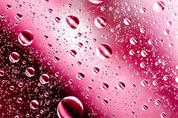 Water drops background on red surface. Water droplets on glass with reflections in them. — Stock Photo, Image