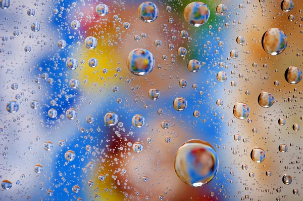 Close up on water drops background on blue, yellow, brown surfac — Stock Photo, Image