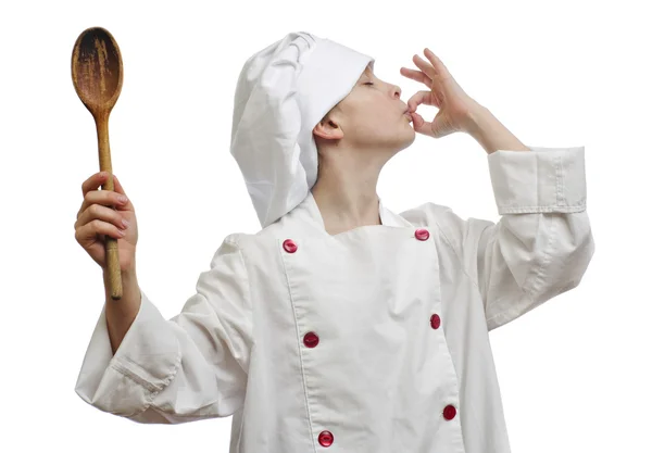 Jovem vestido de chef com colher de madeira no fundo branco . — Fotografia de Stock