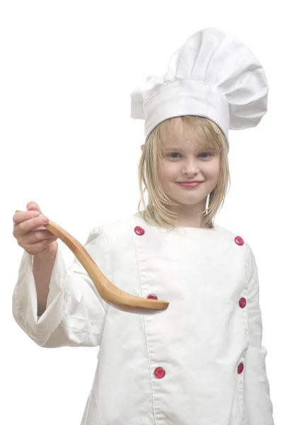 Young girl dressed as chef with wooden spoon on white background — Stock Photo, Image