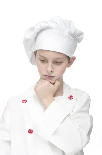 Young boy dressed as chef thinking on white background. — Stock Photo, Image