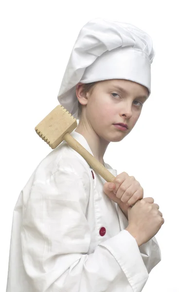 Young boy dressed as chef on white background, holding wooden meat mallet. — Stock Photo, Image