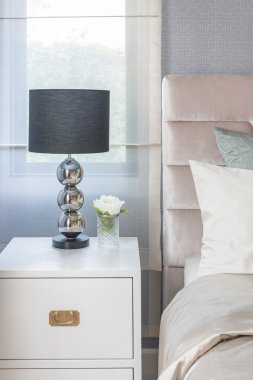 Yatak odasında Beyaz ahşap masa tarafında siyah lamba