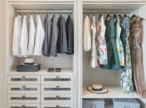 Shirts and dress hanging on rail in wooden wardrobe — Stock Photo, Image