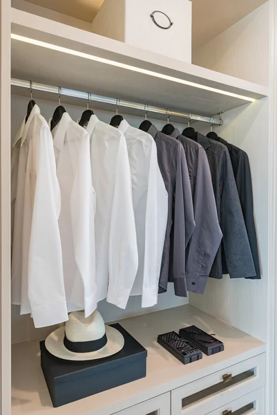Camisas blancas y negras colgadas sobre riel — Foto de Stock