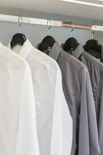 Black and white shirts hanging on rail — Stock Photo, Image