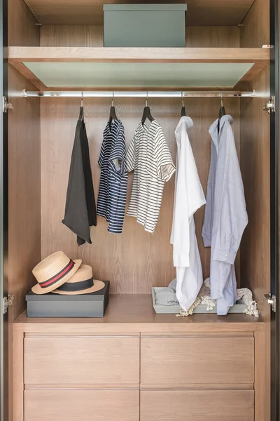 Shirts and suite hanging on rail in wooden wardrobe — Stock Photo, Image