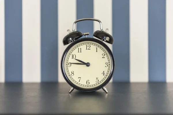 Black alarm clock on wooden table — Stock Photo, Image