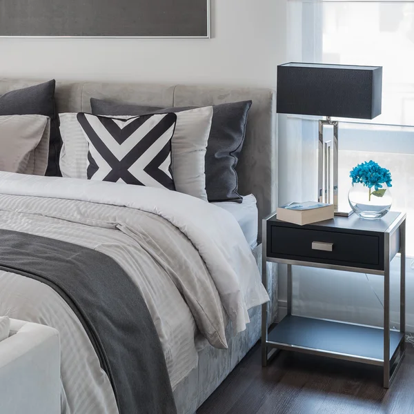 Современная спальня с белой кроватью и черной лампой — стоковое фото