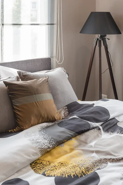 Brown pillow on bed with black wooden lamp in modern bedroom — Stock Photo, Image