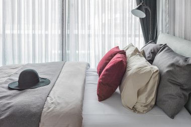 Kırmızı yastık ve yatak modern yatak odasında siyah şapka