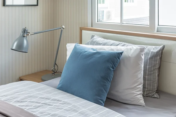 Cuscino blu su letto singolo con moderna lampada grigia in moderno bedroo — Foto Stock