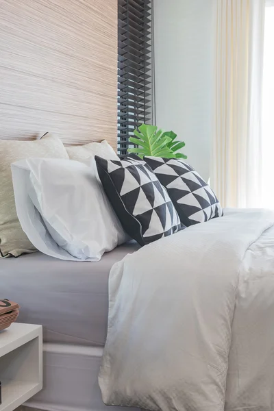 Oreillers noirs et blancs sur le lit dans la chambre moderne — Photo