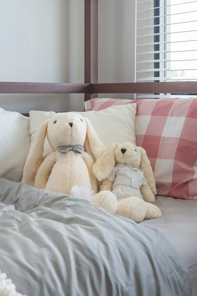 Κούκλες και παιχνιδιών στο κρεβάτι στην κρεβατοκάμαρα του παιδιού — Φωτογραφία Αρχείου