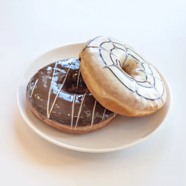 Белый шоколад и шоколадные пончики на тарелке — стоковое фото
