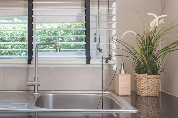 Spüle mit Wasserhahn auf schwarzer Küchentheke — Stockfoto