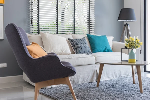 Modernes Wohnzimmer mit modernem Stuhl und Sofa mit Pflanzenvase Stockbild