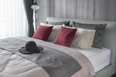 Kırmızı yastık ve yatak modern yatak odasında siyah şapka 