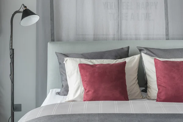 Lámpara negra en diseño moderno dormitorio con almohadas rojas — Foto de Stock