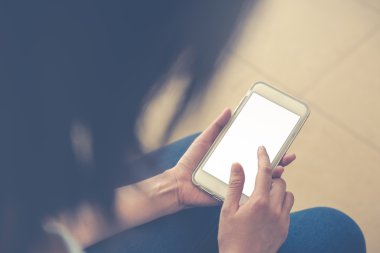 Akıllı telefonu elinde tutan genç bir kadın. 