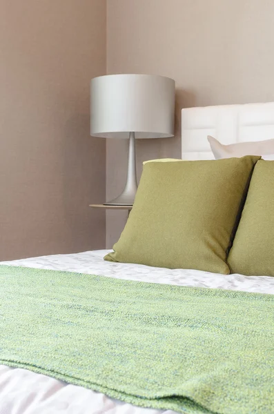 Zielony pillw na łóżku z lampy nowoczesne styl na drewniany stolik — Zdjęcie stockowe